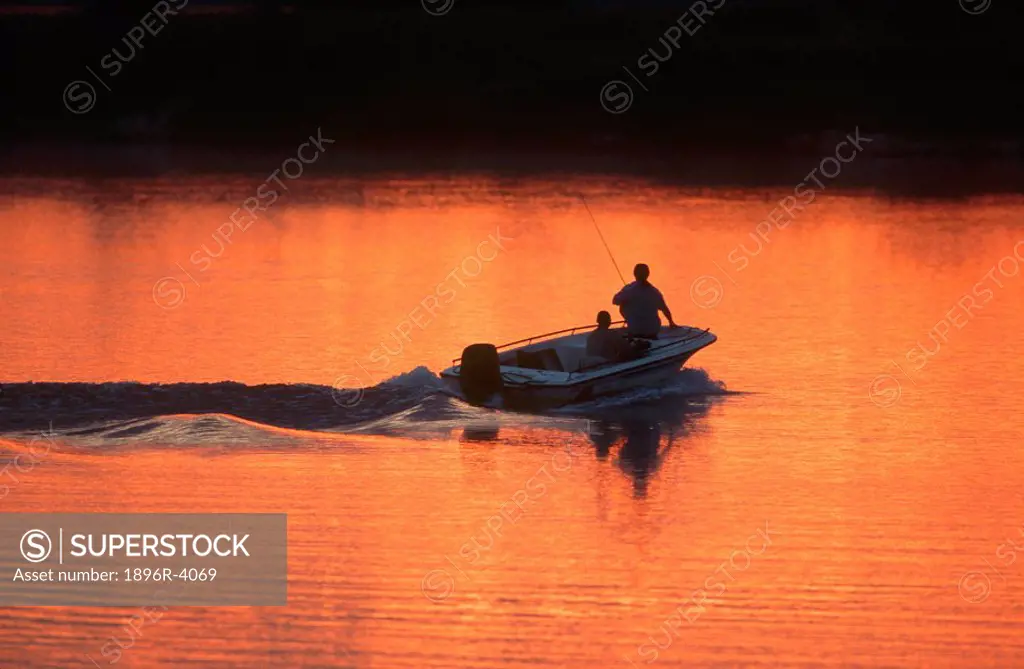 Fishing Boat on Move with Men Silhoetted in the Morning Light  Chobe River, Namibia, Africa