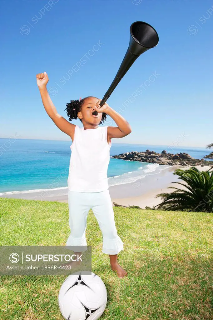 Young African Girl with a Soccer Ball, Blowing a Vuvuzela Horn  Cape Town, Western Cape Province, South Africa