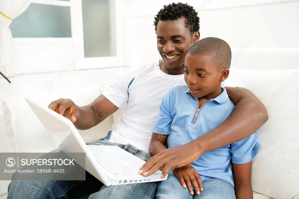 Young African Boy with his Father on a Laptop  Cape Town, Western Cape Province, South Africa