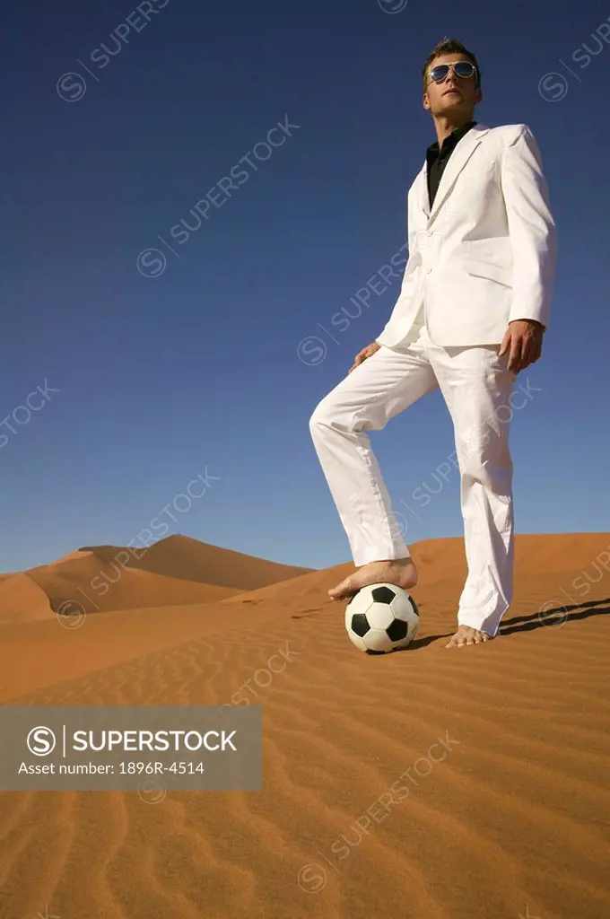 Man in a White Suit Standing on a Soccer Ball in the Desert  Namibia
