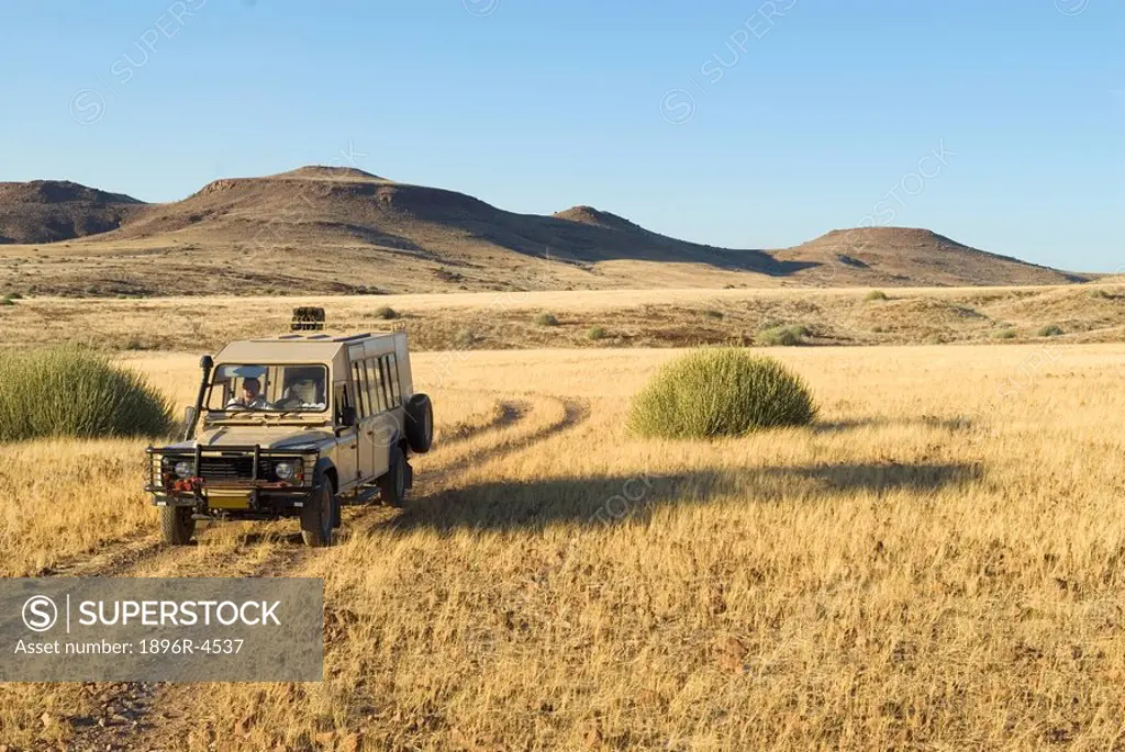Tourist On Safari in a 4X4Vehicle  Palmwag Rhino Camp Area, Damaraland, Palmwag Concession, Namibia, Africa