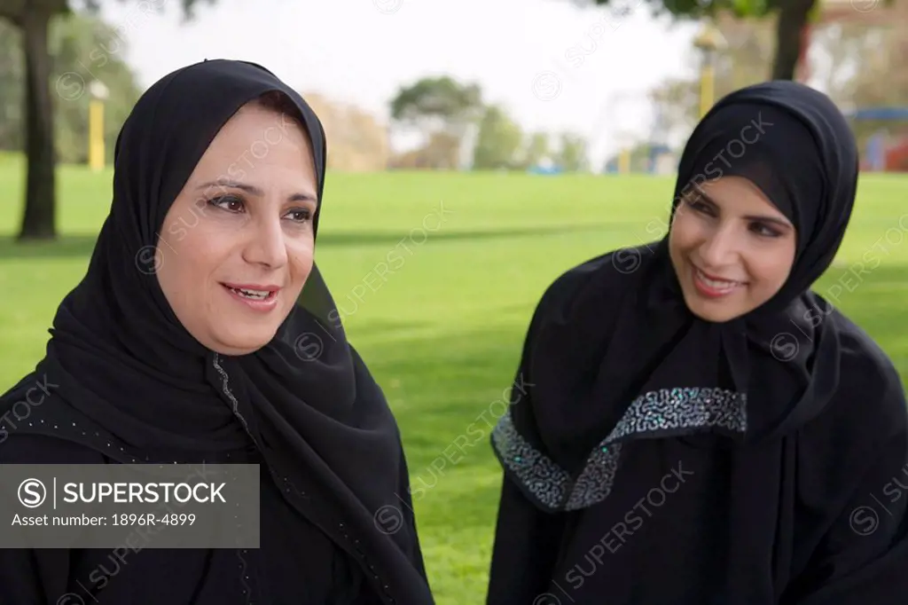 Arab Mother and Daughter Smiling Together on Grass in Park  Dubai, United Arab Emirates