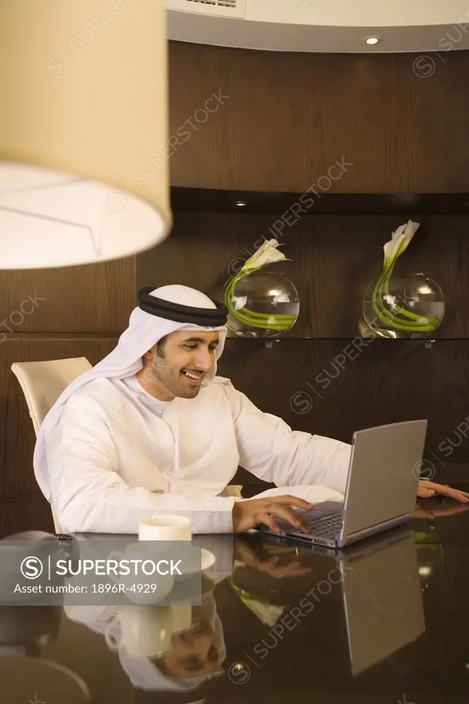 Arab Man Working on Laptop Computer at Desk  Dubai, United Arab Emirates