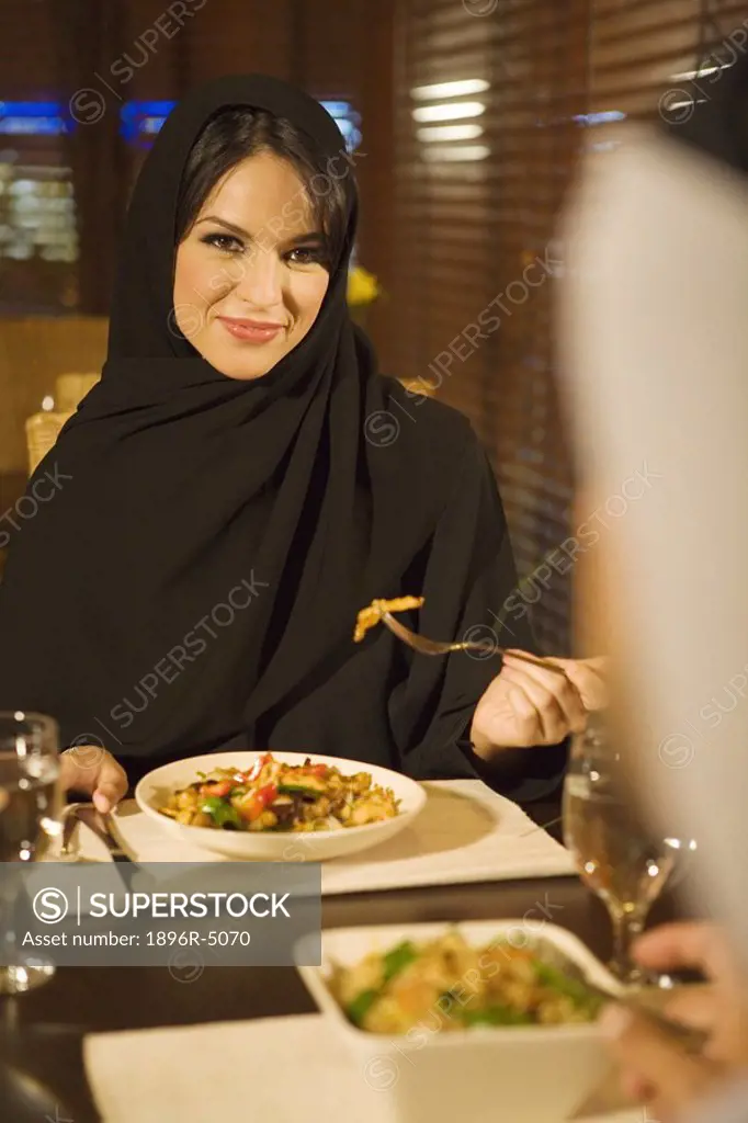 Arab woman dining with husband in restaurant  United Arab Emirates
