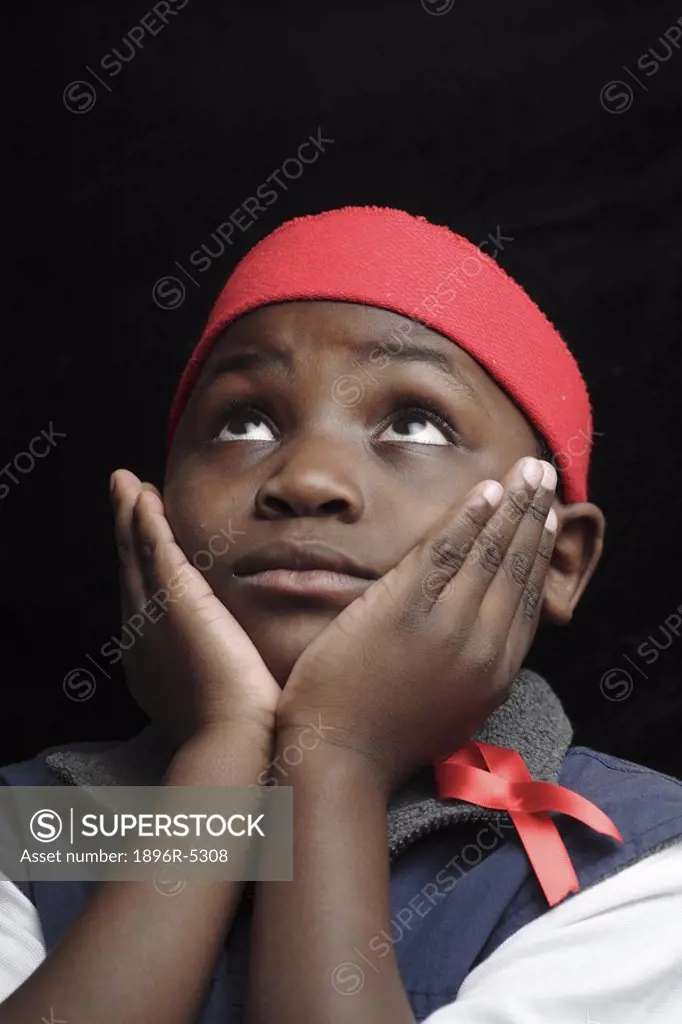Young Boy Looking Up with His Hands On His Cheeks  Studio Shot