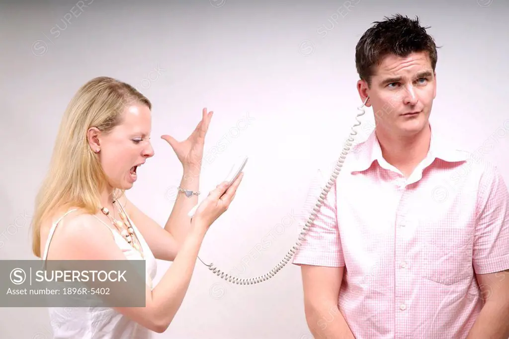 Woman Screaming Down a Phone Connected to a Man  Studio Shot