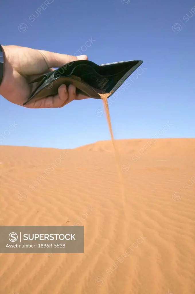 Businessman Emptying Desert Sand from his Wallet  Namibia