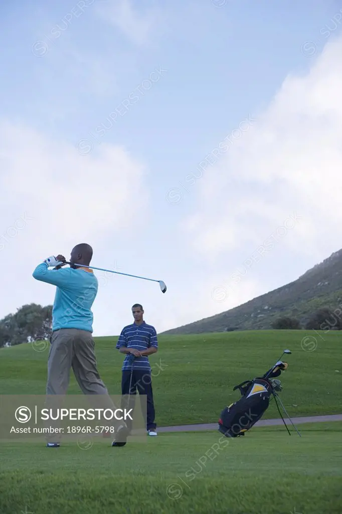Low Angle View of Man Swinging Golf Club  Clovelly Golf Course, Cape Town, Western Province, South Africa
