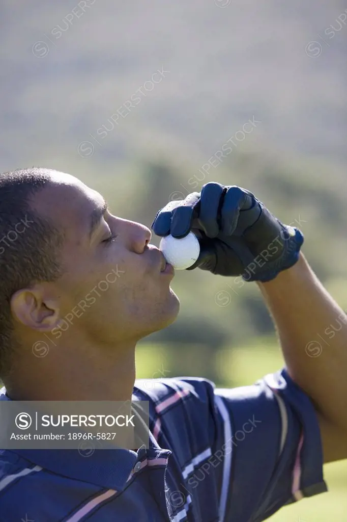 Close Up of Man Kissing Golf Ball  Clovelly Golf Course, Cape Town, Western Province, South Africa