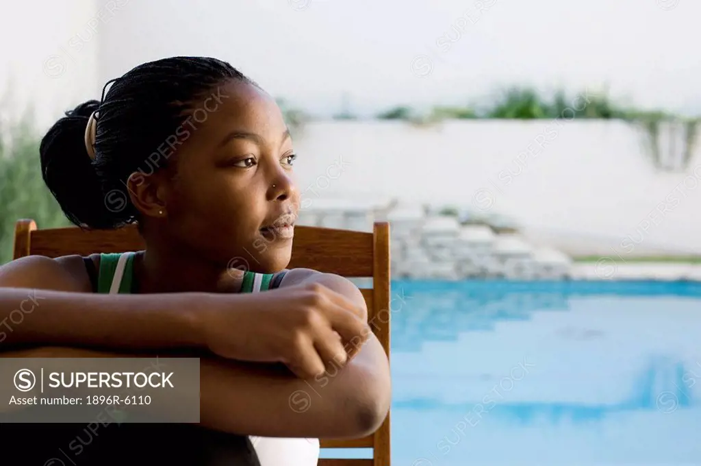 A young woman deep in thought, on the patio at home, Johannesburg, Gauteng Province, South Africa