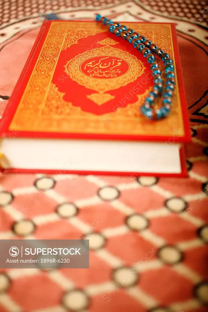 Koran and praying beads, placed on a praying carpet. Dubai, United Arab Emirates