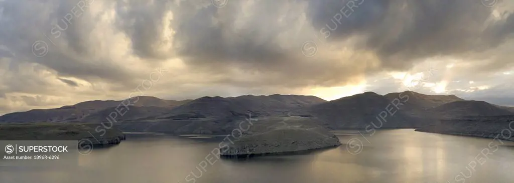 Snow clouds form over the expance of Katse Dam and are refelcted in the water. Katse dam, Lesotho, South Africa
