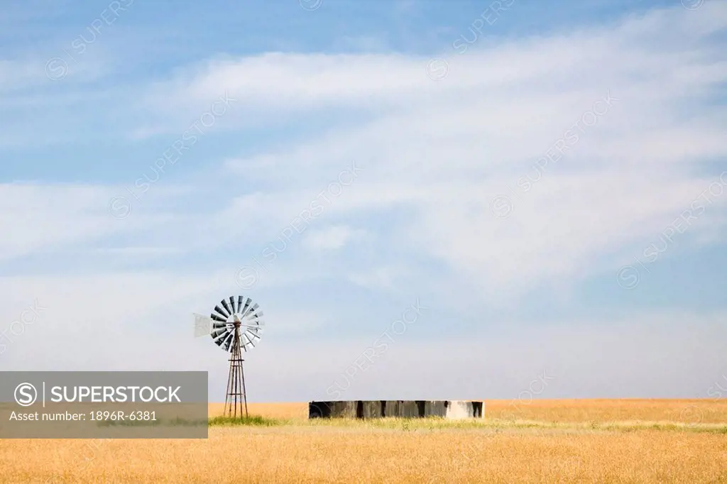 The vastness of a Free State Province farm, with typical windmill and dam in the grasslands. South Africa