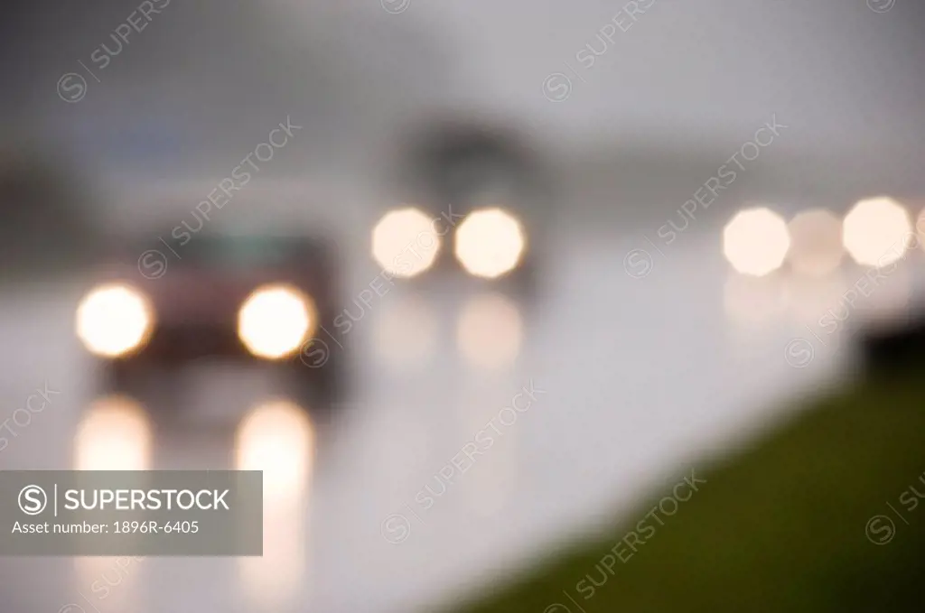 Car lights through wet misty weather on a Cape Town highway. Tokai, Cape Town, Western Cape Province, South Africa