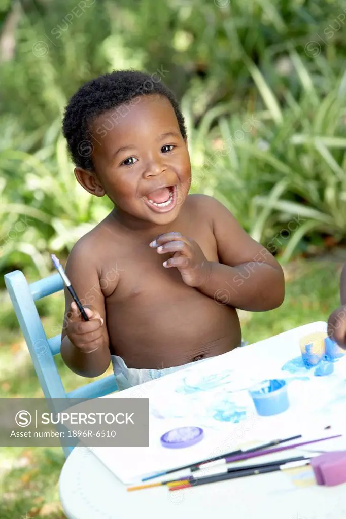 Pre_school boy painting outdoors.Cape Town, Western Cape Province, South Africa