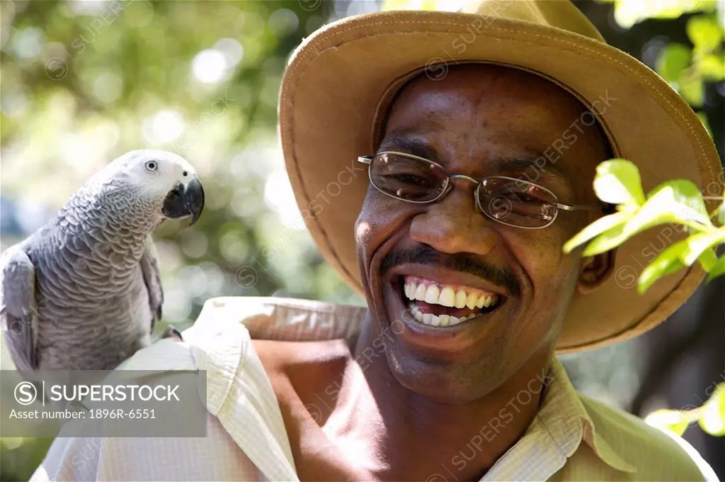 Tour Guide smiling with an African Grey Parrot on his shoulder. Kenya