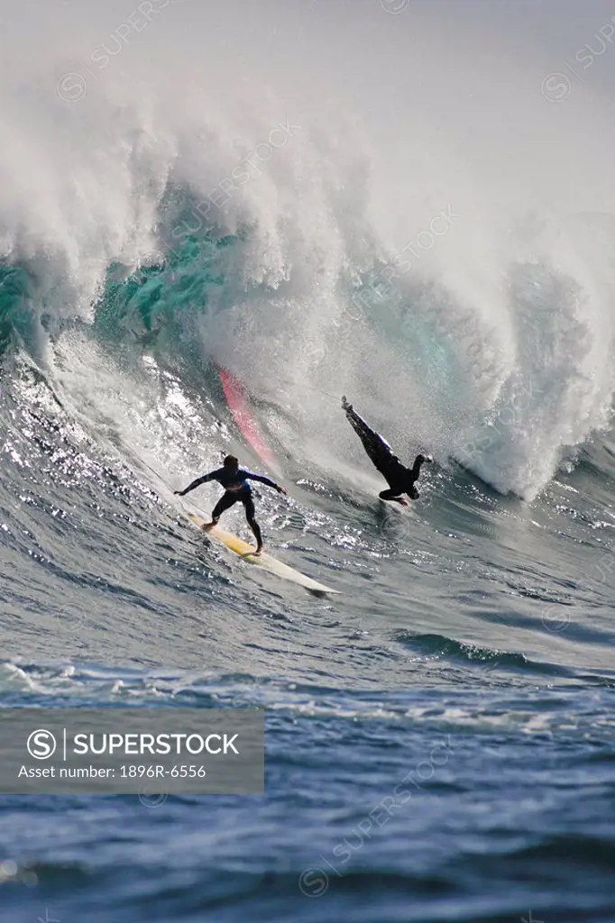 Surfers on a big wave that storms in from the Antarctic each year to hit the infamous offshore reef outside Hout Bay known as Dungeons. Cape Town, Wes...