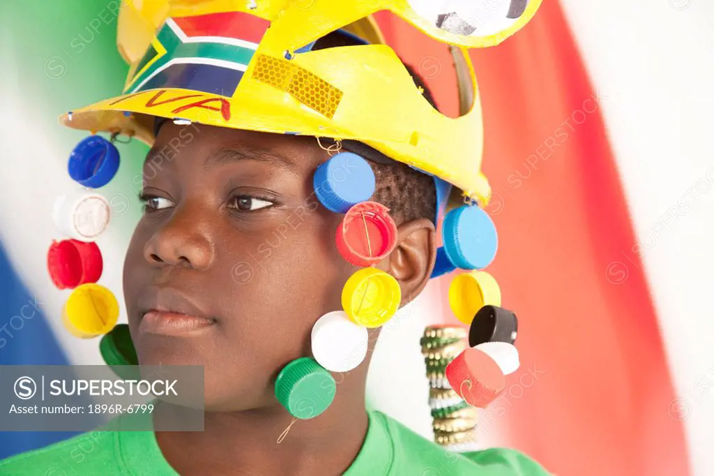 A young black soccer supporter wearing a traditional soccer Makaraba with the South African flag waving, South Africa
