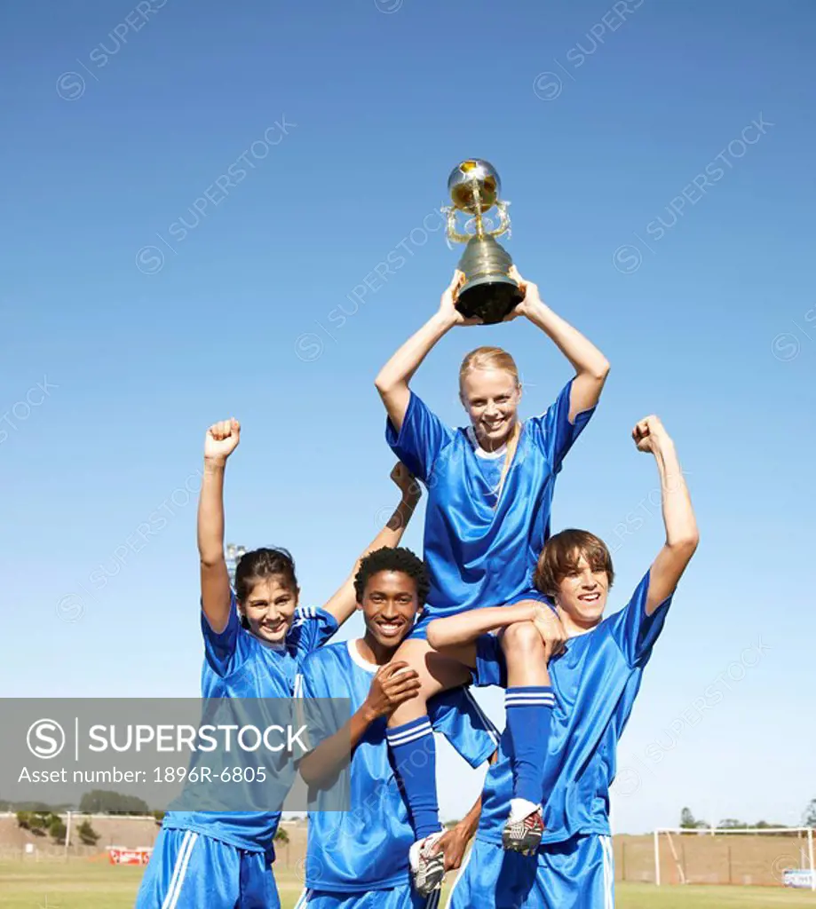 Soccer team holding up winning trophy with pride. Cape Town, Western Cape Province, South Africa