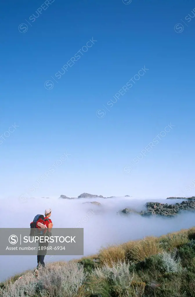 High angle view of hiker admiring the misty mountain view. Cederberg, Western Cape Province, South Africa.