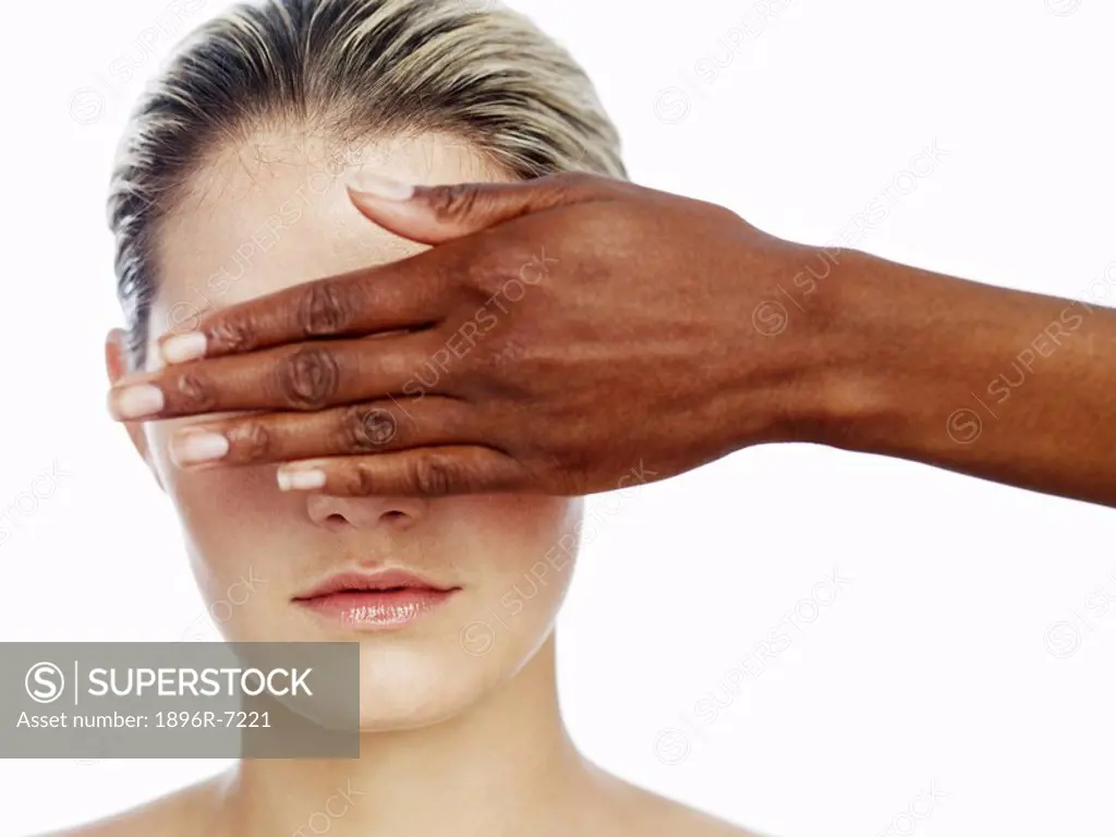 Woman With Another Woman´s Hand Covering her Eyes  Studio Shot