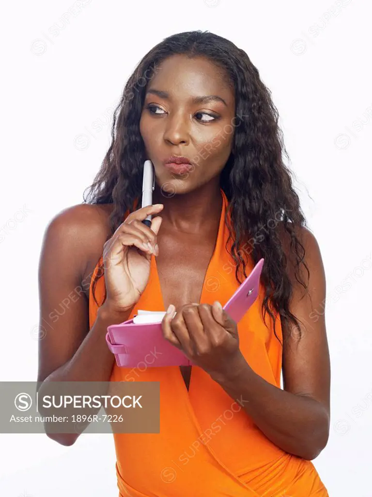 Woman Holding a Pen to her Cheek Deep in Thought  Studio Shot
