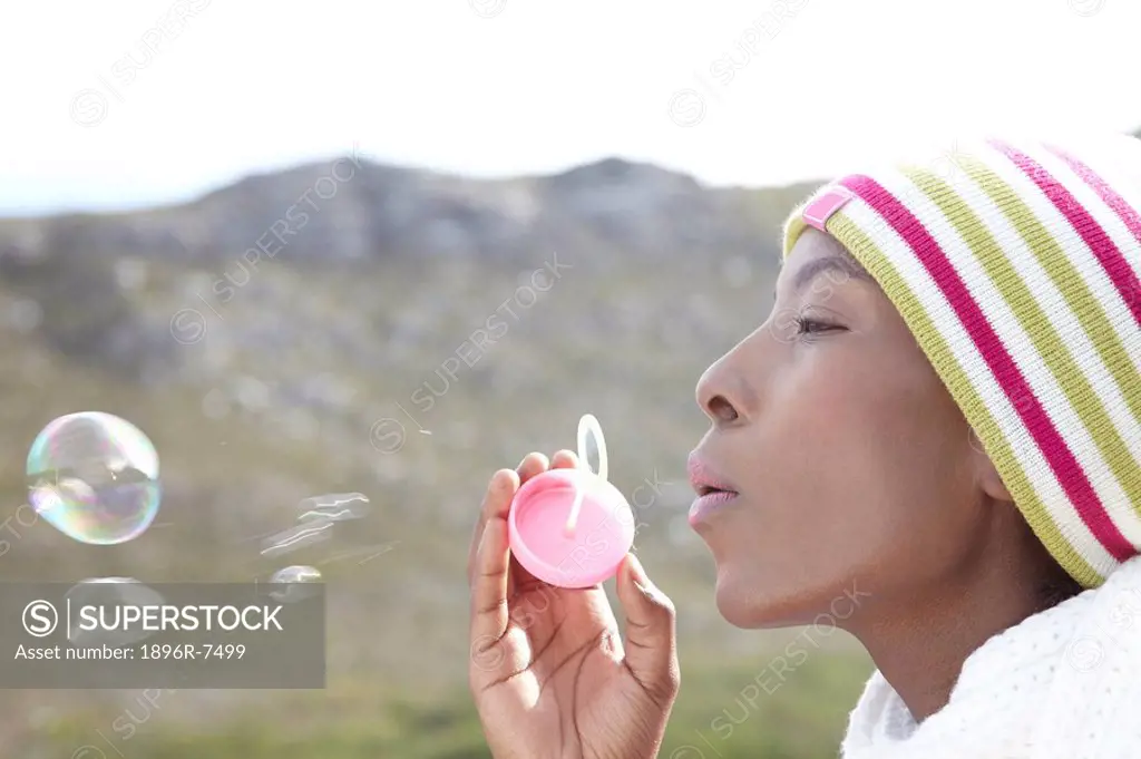 Woman blowing bubbles outdoors, Cape Town, Western Cape Province, South Africa