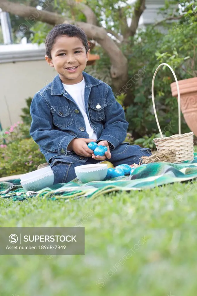Young boy siiting the yard with easter eggs, South Africa