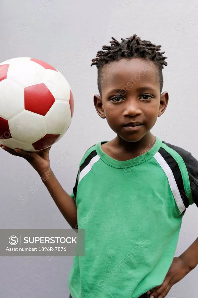 Boy holding up soccer ball, Cape Town, Western Cape Province, South Africa