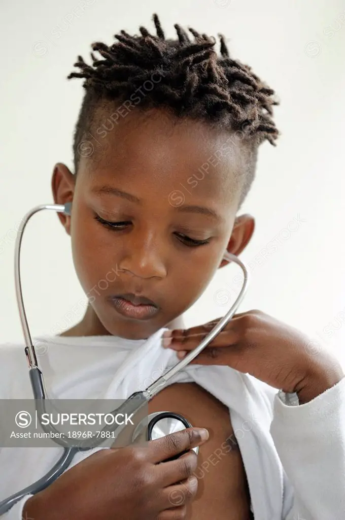 Boy listening to own heartbeat with stethoscope, Cape Town, Western Cape Province, South Africa