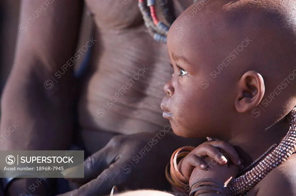 Profile view of a Himba child and torso of man, Van Zyl,Äôs Pass area, Kaokoland, Namibia