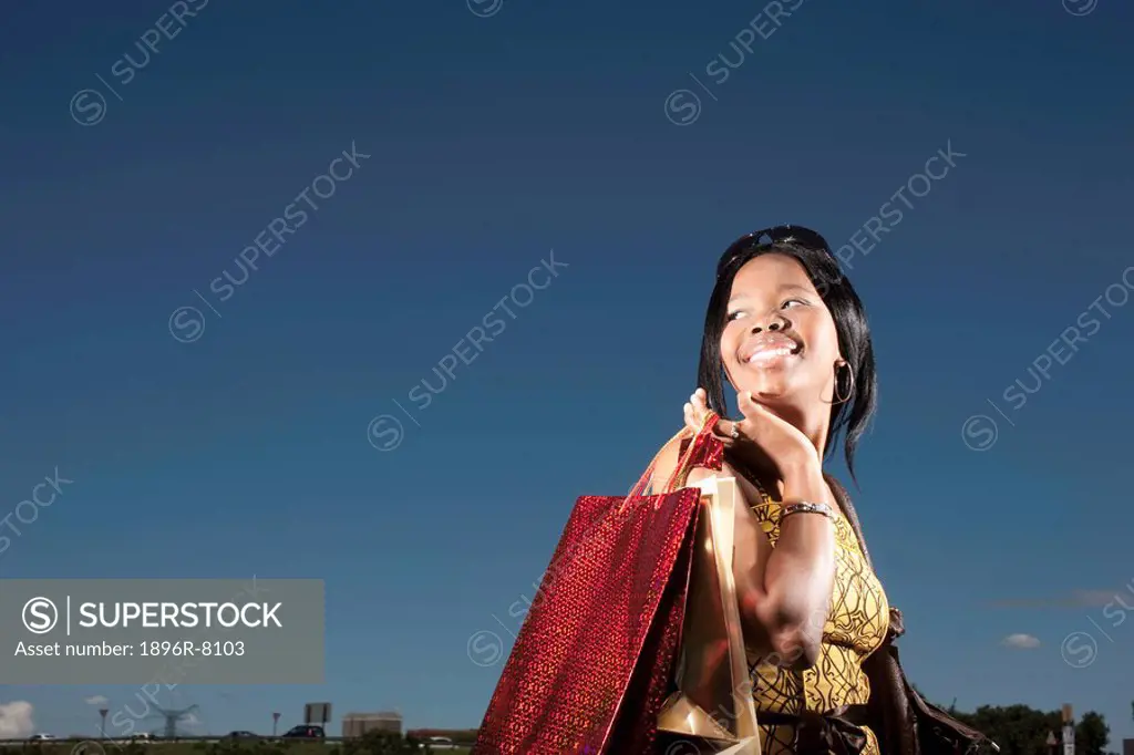 Low angle of young woman holding shopping bags, KwaZulu Natal Province, South Africa