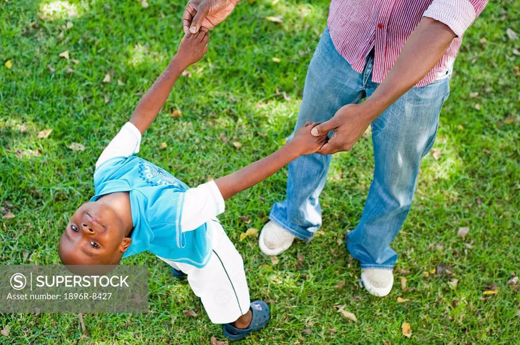 Boy 4_5 playing with father on lawn in garden, Johannesburg, Gauteng Province, South Africa