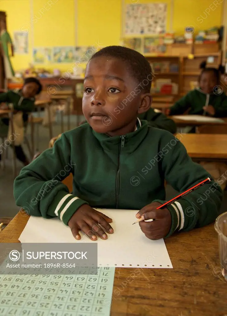 Young schoolboy prepares to write during class, KwaZulu Natal Province, South Africa