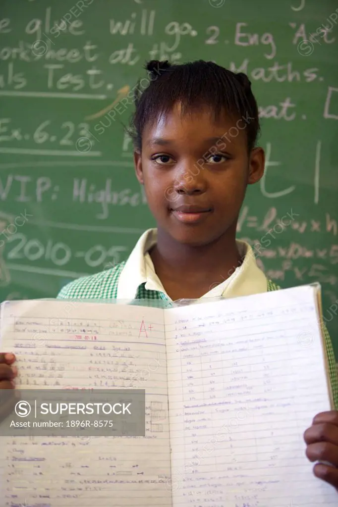 Schoolgirl standing at the front of her class showing and A+ paper, KwaZulu Natal Province, South Africa