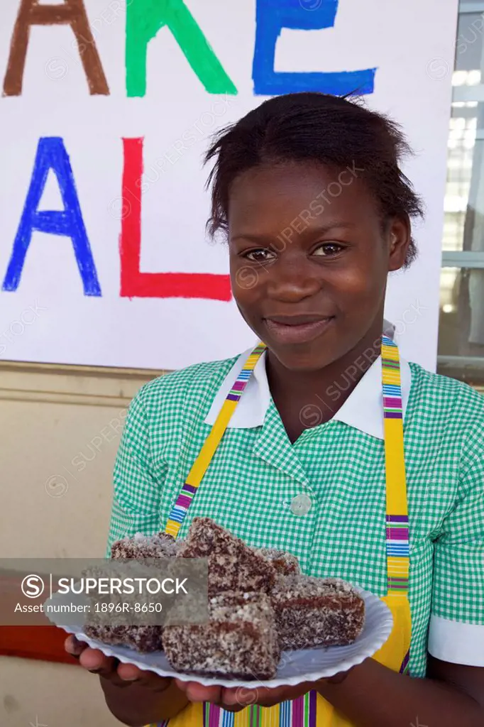 Schoolgirl standing with sweet treats at a school cake sale, KwaZulu Natal Province, South Africa