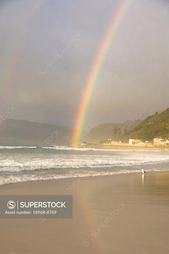 Rainbow over Kalk Bay Mountains and Muizenberg Beach at sunrise, Muizenberg Beach, Cape Peninsula, Western Cape, South Africa
