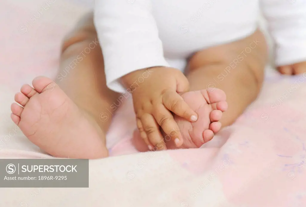 Close up of a baby feeling her feet, Cape Town, South Africa.