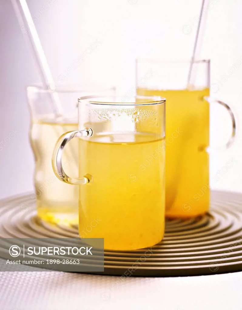 Hot toddy in glass mugs on a corrugated, circular tray.