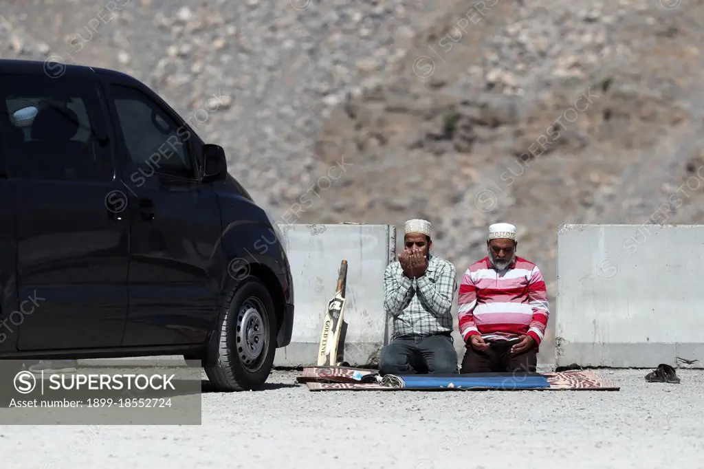 Muslim men performing salah during ramadan.   Jebel Jais. United Arab Emirates.