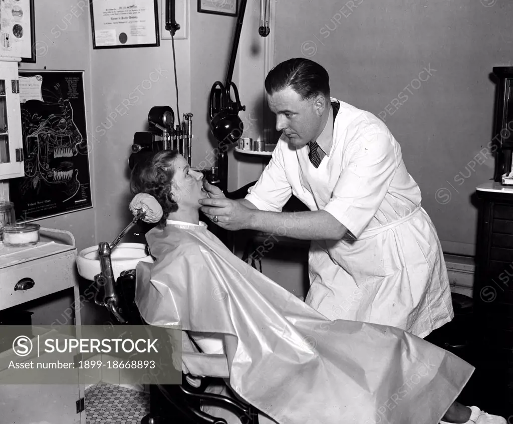 Dentist examining a patient circa 1936.
