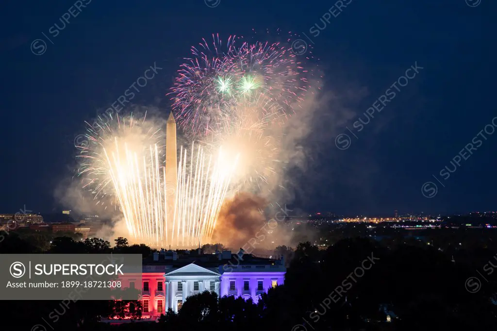 Reportage: Fireworks appear above the White House North Portico lit in red-white and blue lights Saturday evening, July 4, 2020, during the Salute to America 2020, Fourth of July celebration.