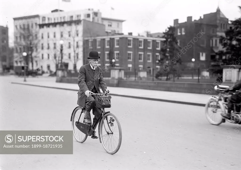 Old man riding his bicycle to work circa 1914. 