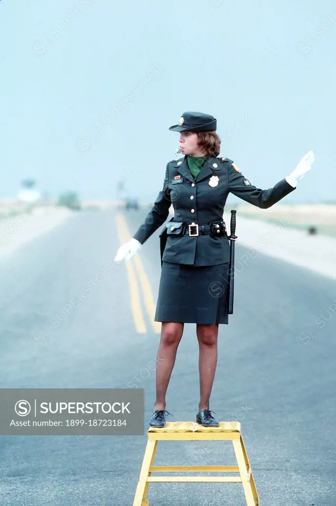 1979 - A U.S. Army military policewoman directs traffic.