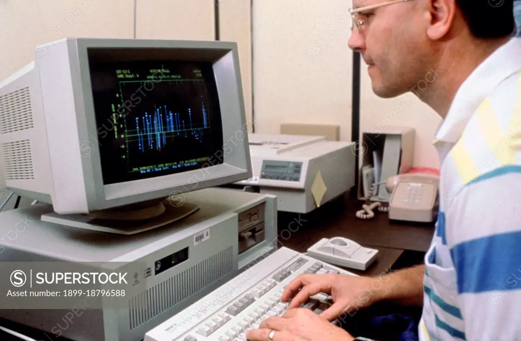 Scientist analyzing data on computer screen ca. 1996. 
