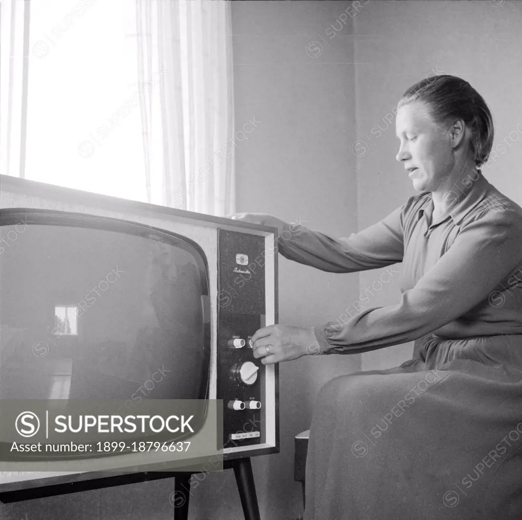 Finland History -  Smallholder Lempi Kuikka with a TV-set she won from a competition organized by Kuluttaja magazine. There is no picture on the screen, as the Kuikkas' house didn't have electricity.  ca. 1963. 
