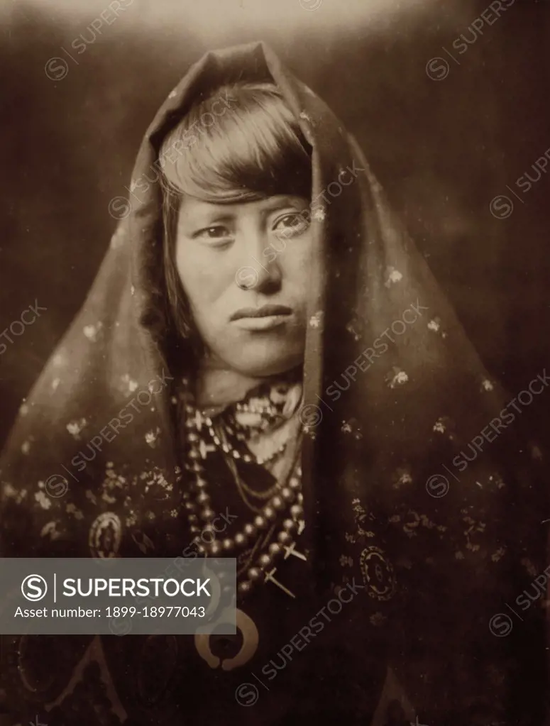 Edward S. Curits Native American Indians - Head-and-shoulders portrait of an Acoma woman, facing front, with head covered and wearing jewelry ca. 1905. 