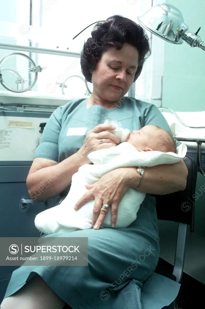1974 - A nurse feeds an infant. 