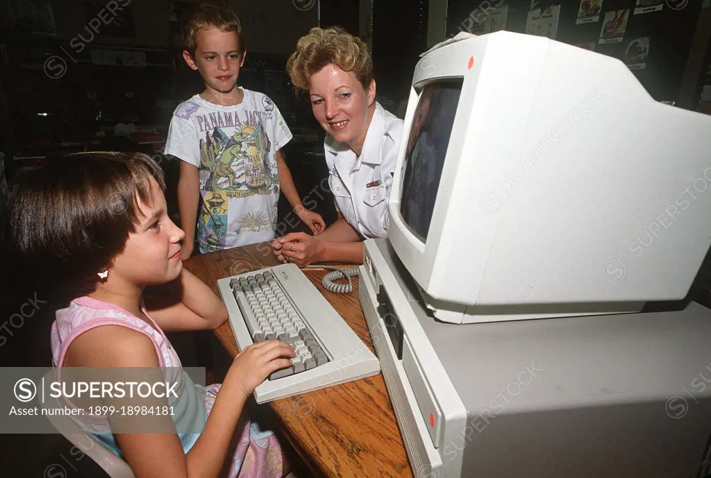 1989 - A Data Processing Technician explains a computer program to children from Warrington Middle School. . 