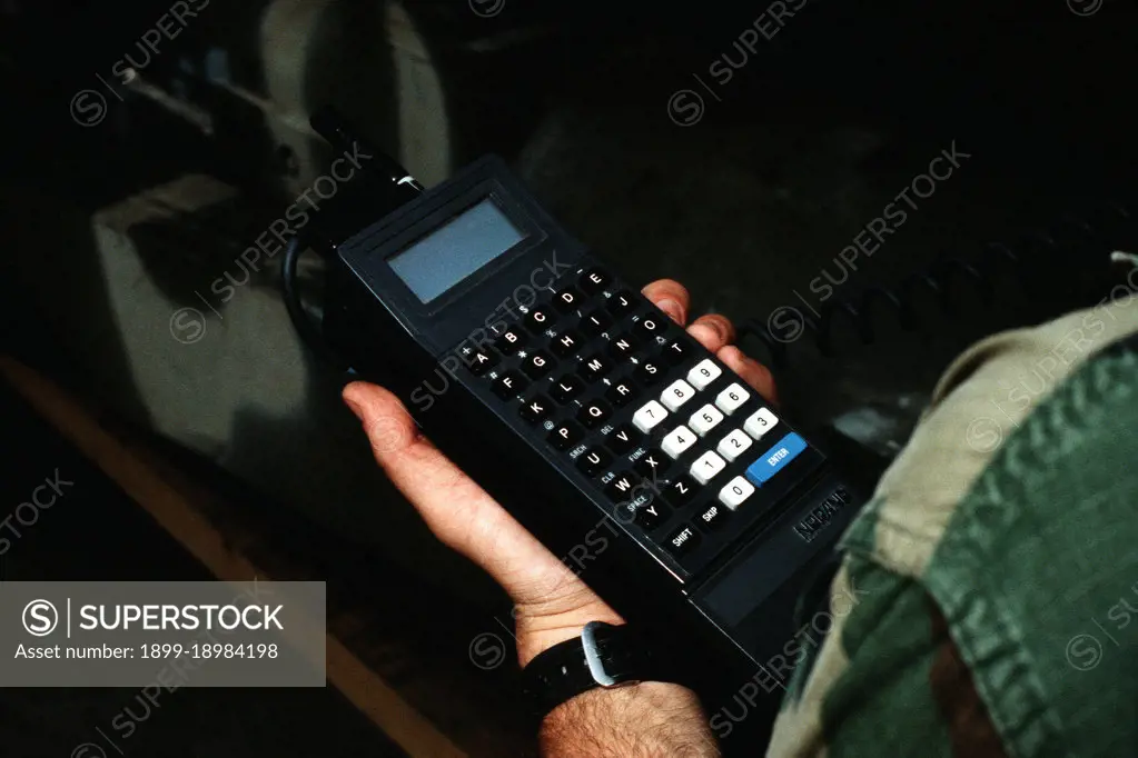 A Marine holds a small computer that he is using to take inventory of the vehicles and equipment brought ashore from maritime pre-positioning ships during exercise Ocean Venture '88.. 